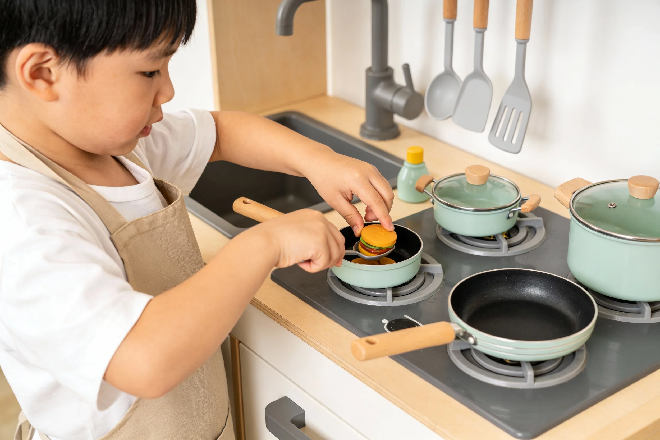 Child using a real cooking set