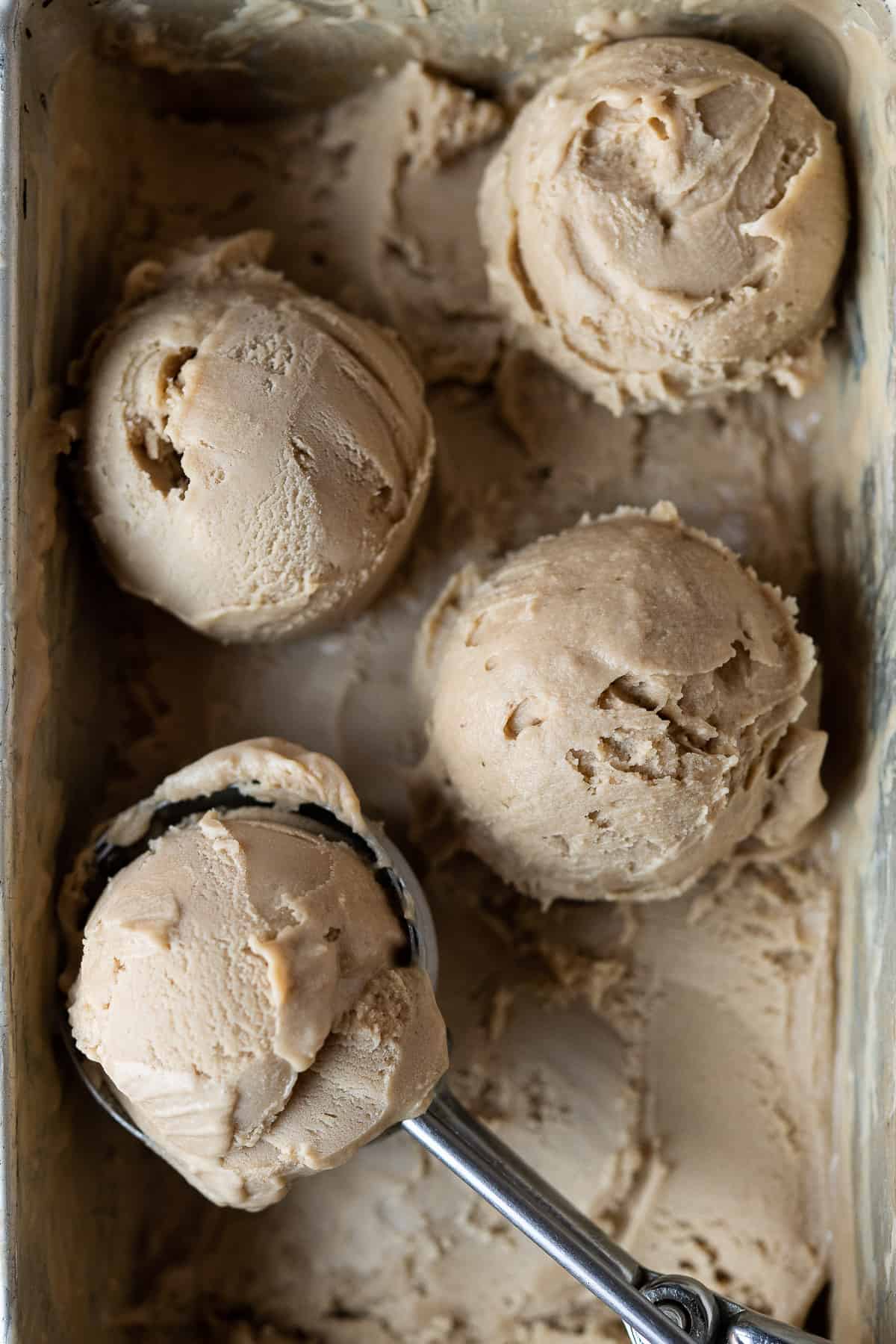 Scoops of vegan biscoff ice cream in a loaf tin.